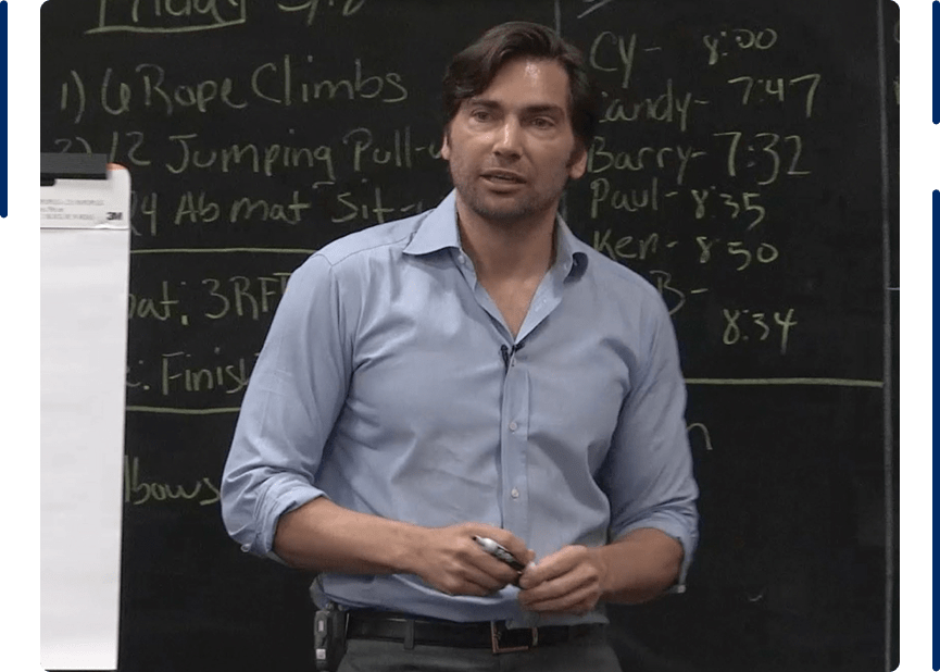 Dr. Dave Clayton, MD, speaking in front of a chalkboard